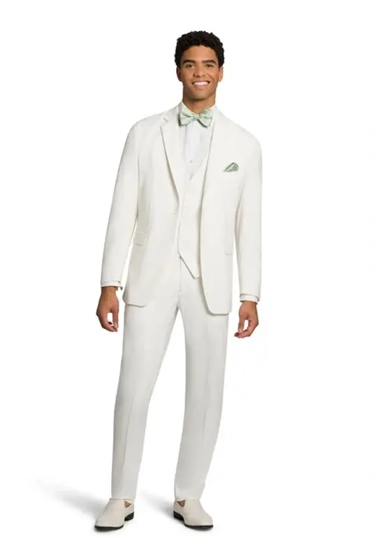 A man in white suit and green bow tie.