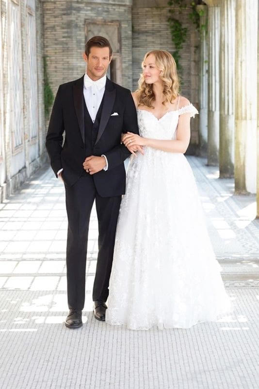 A man and woman in wedding attire walking down the aisle.