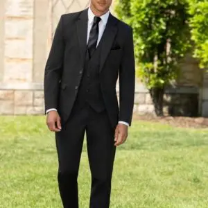 A man in suit and tie standing on grass.