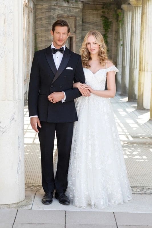 A man and woman in formal wear posing for the camera.